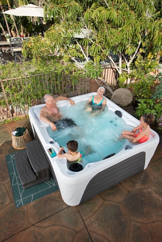 Grandparents with grandkids in outdoor Fantasy Spas Premier series hot tub