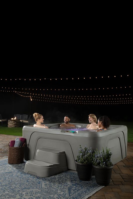 Friends enjoying time in a Fantasy Spas hot tub at night